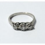 Diamond three-stone ring with brilliants approximately .15ct and .3ct, 'plat'.