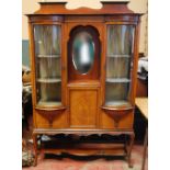 Edwardian inlaid mahogany display cabinet enclosed by two bowed glazed doors, on cabriole legs.