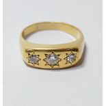 Gent's diamond ring with three brilliants, approximately .40ct and .15ct, star-set in gold, '18ct'.