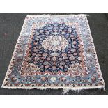 Qum rug with ivory medallion and indigo field within a pale blue triple border,