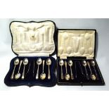 Two sets of six silver coffee spoons, each with tongs, cased.