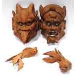 Pair of carved wood grotesque masks, 12cm long, and a pair of Chinese carp, 10cm long.