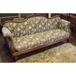 A Victorian carved mahogany salon scroll end settee, with serpentine back and floral upholstery,