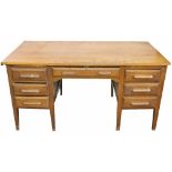 A vintage golden oak desk, with an arrangement of seven drawers, on tapered legs,