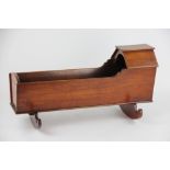 A 19th century mahogany dolls crib, with hood, on two rockers, 55cm long,