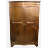 An early 20th century mahogany bow front wardrobe, with two panelled doors,