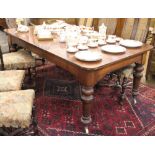 A Victorian mahogany dining table, on turned and tapered legs, fitted ceramic casters,
