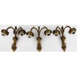 Three gilt metal twin branch wall lights, of Adam design with rams mask back plates,