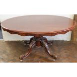 A Victorian mahogany oval loo table, the top with a serpentine edge, on a turned baluster column and