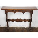 A modern French stained pine side table, with heraldic carved drawer, on standard end supports,