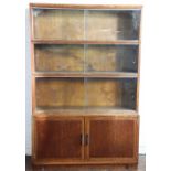 A Minty style oak four section book case, with three glazed sections above two cupboard doors,