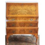 A 1930's walnut bureau, with fall and three long drawers, on shell carved cabriole legs,