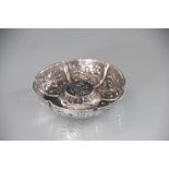 An Edwardian silver dish, of circular form and with repousse segmented panels,