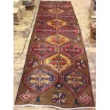 A Persian wool runner, worked with fourteen geometric gulls against a beige ground,