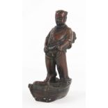 A Japanese bronze 'nude' boy, modelled standing on a raft with a dog,