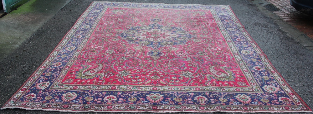 A Tabriz hand woven wool carpet, worked with an all over foliate design against a blue ground,