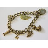 A 9ct gold charm bracelet with attached padlock clasp and six charms including, a duck, a key,