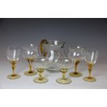 A set of six clear and amber glass hock glasses, with a matching jug, eleven similar champagne