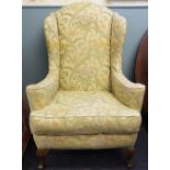 A pair of 1920's wingback arm chairs, with floral green upholstery,