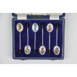 A set of six silver and enamel coffee spoons, each bowl decorated with a different flower,