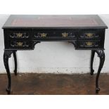 A Victorian carved and ebonised desk, with leather inset top and five drawers on cabriole legs,