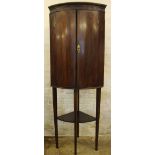 A 19th century inlaid mahogany bow front corner cabinet on stand, with two doors enclosing shelves,