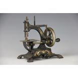 A late 19th century miniature sewing machine, No 23161, cast iron frame with gilt detailing,