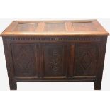 An 18th century carved oak coffer with later panelled top, on moulded stile feet,