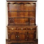 A George III style oak high back dresser, with three tier plate rack flanked by two small cupboards,