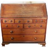 An early 19th century provincial oak bureau with fall enclosing a fitted interior with twenty