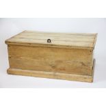 A small pine box, with hinged four plank lid, on moulded base, 26cm H x 65cm W x 38.