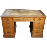 A late Victorian golden oak pedestal desk, with an arrangement of nine drawers, on plinth base,