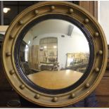 A Regency style gilt framed circular convex mirror, with sphere detail,