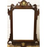 A George III style walnut wall mirror, with angled plate within a  fret cut type frame,