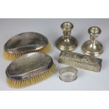 A pair of silver dwarf candlesticks, Birmingham 2004, a pair of silver backed brushes,