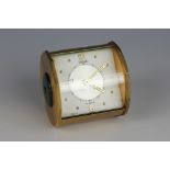 A Jaeger gilt brass eight day desk alarm clock, Arabic and button dial with green dish sides,