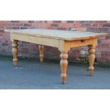 A pine farm house kitchen table, with two drawers on turned legs,