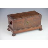 A Regency mahogany tea caddy, with turned side handles and beaded edges, on gadrooned bun feet,