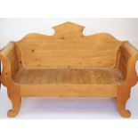 A modern waxed pine scroll end hall settle, on scroll legs,