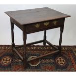 A late 17th century oak side table, with three plank top, above a drawer, on turned legs,