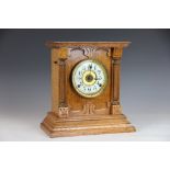 A late Victorian oak mantle clock with enamel Arabic dial and movement striking on a gong,