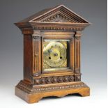 A late Victorian oak mantle clock with silvered Arabic dial and movement striking on a gong,