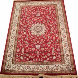 A Kashmir rug, worked with an all over foliate design against a red ground,