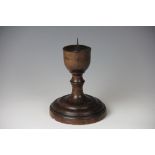 An 18th century turned wood pricket candlestick, with butter pritt base,