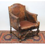 A 1920's stained beech tub chair, of 17th century style, with leather upholstery,