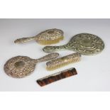 A silver four piece dressing table set, comprising hand mirror, hand brush, comb and brush,