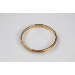 A yellow metal slave bangle, of plain polished form and stamped '15ct', weight 12.