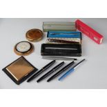 A collection of pens and powder compacts, to include; a Platignum Varsity De Luxe and a Regal,