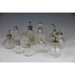 Eleven assorted silver topped jars, perfume atomisers,