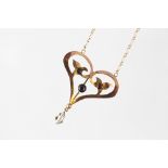 An Art Nouveau garnet and mother of pearl set pendant, the pendant of heart shaped,